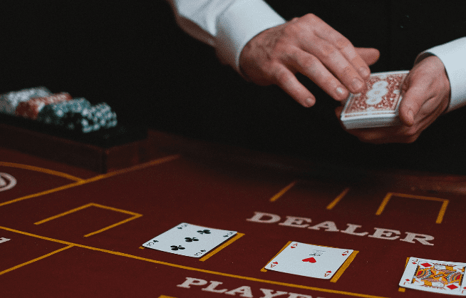 Poker dealer getting ready to place a card on the table